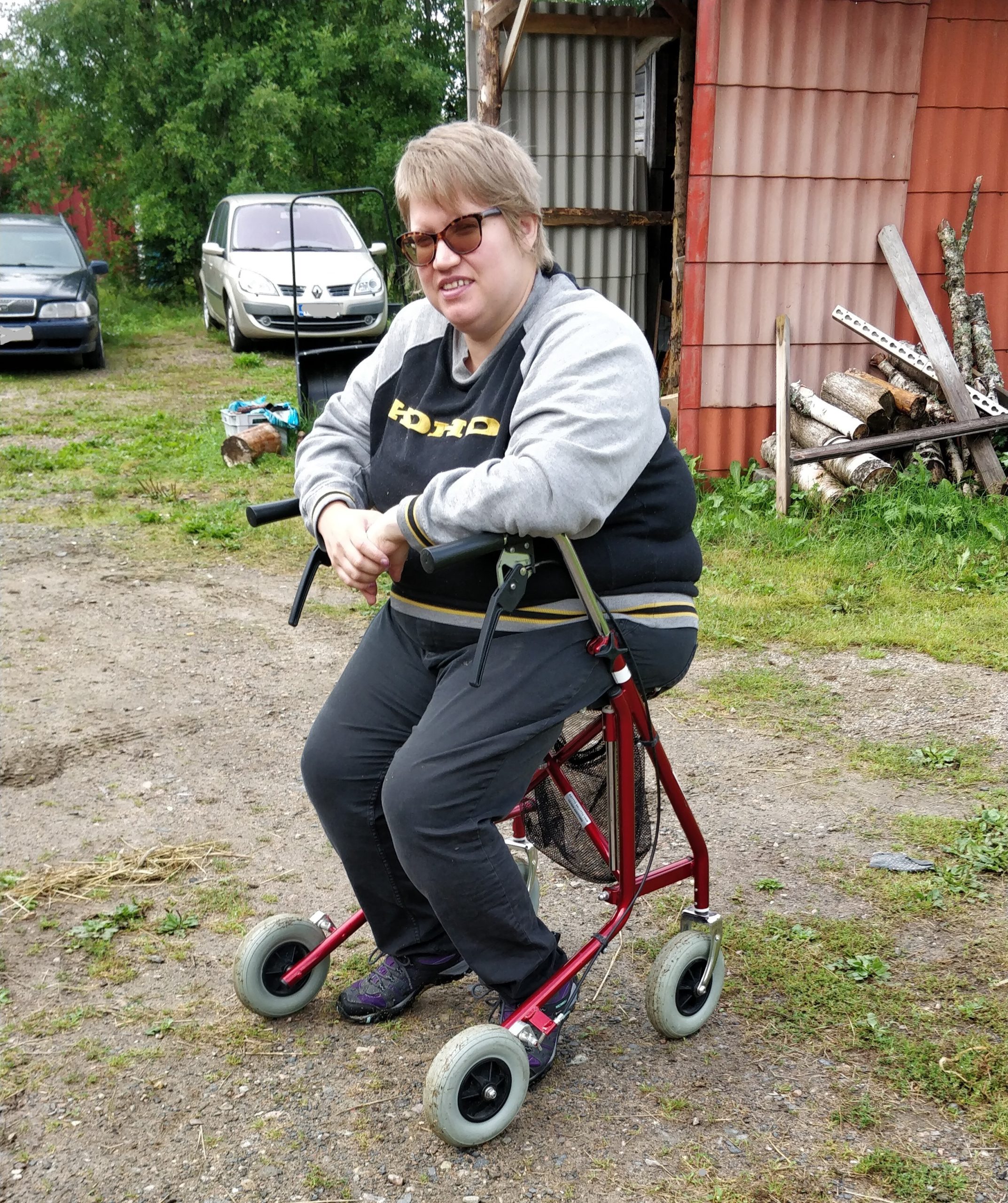 Hanna-Kaisa sitting on rollator, with mild smile